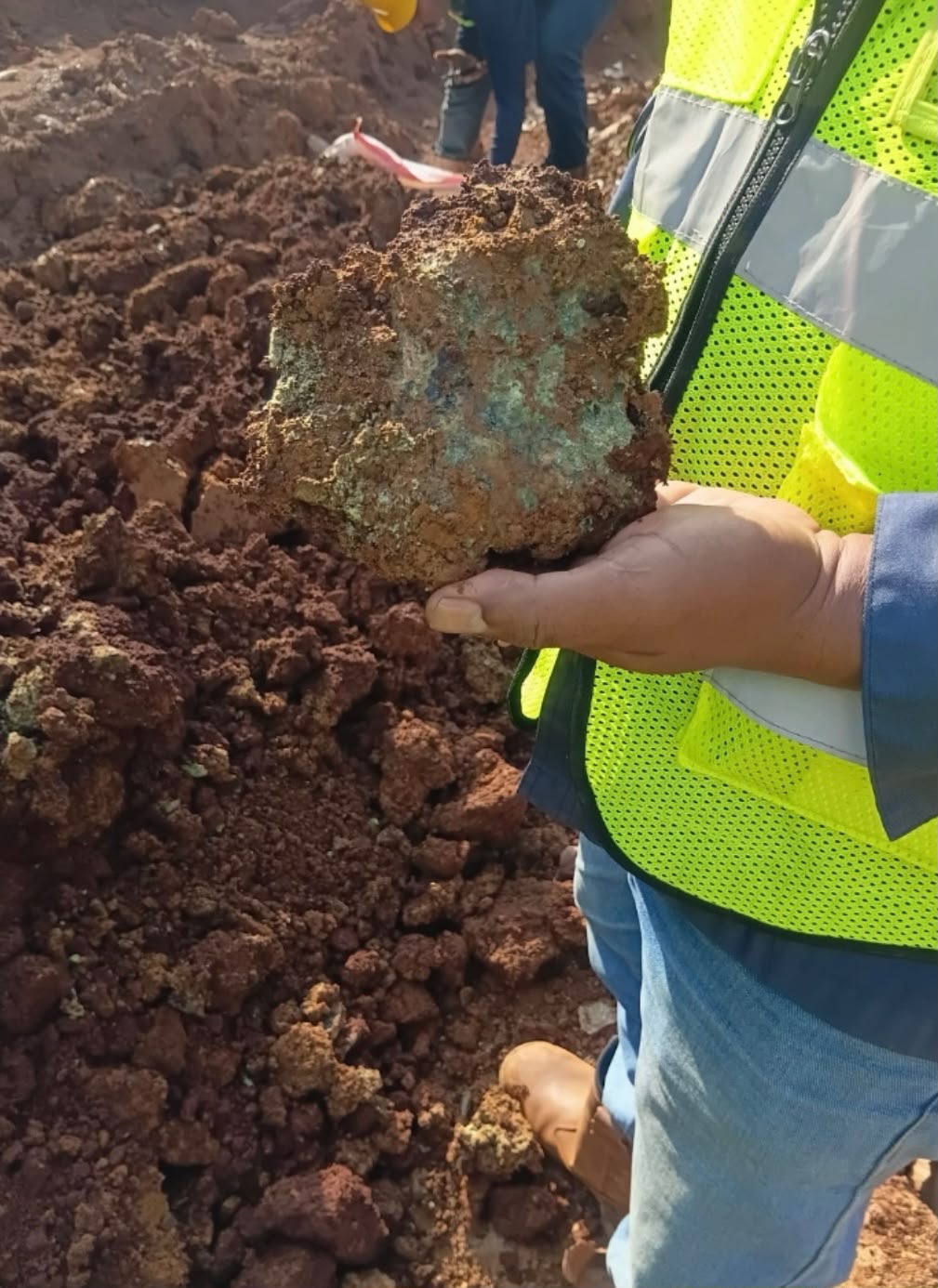 Field team member holding a mineral sample