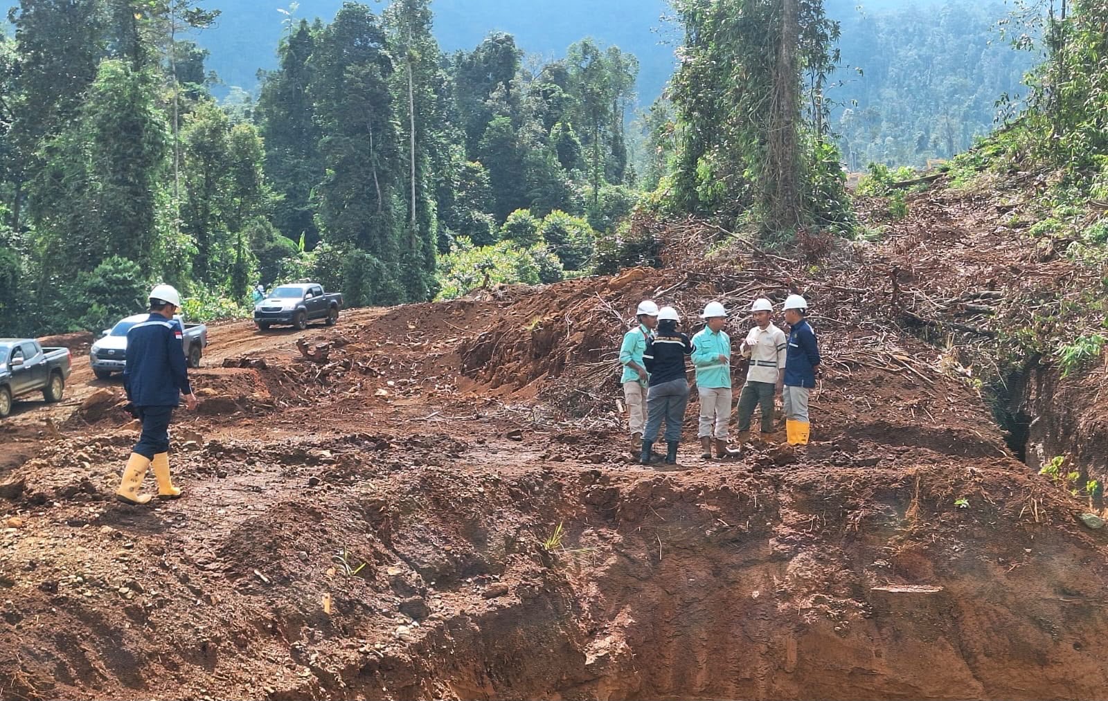 Visitors in hardhats inspecting the wider mining site